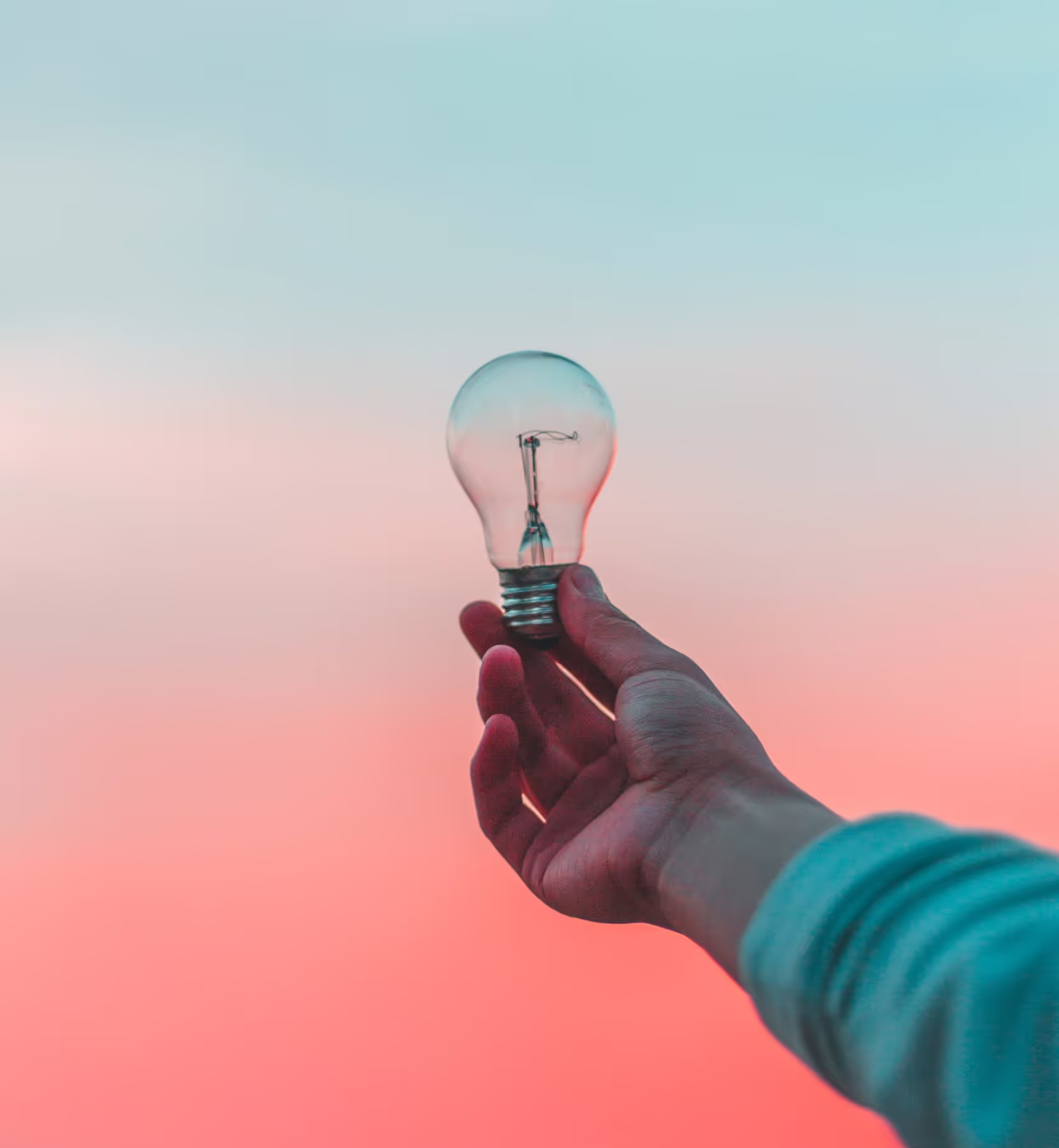 A person holding a bulb up to the sky, like an idea moment.